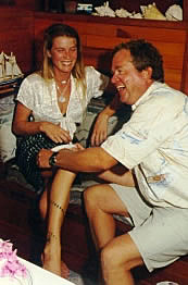 Capt. Jeff slips the garter onto Lisa's leg